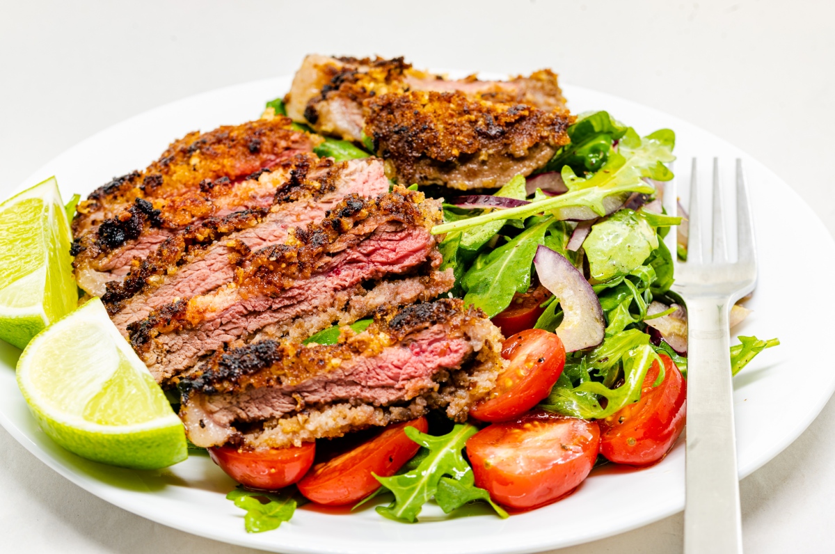 Crumbed, nutted, and beaten rump steak with rocket salad